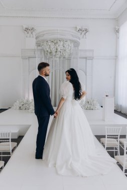 Güzel genç gelin ve damat düğün töreninde poz veriyor.