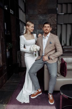 Mutlu stil sahibi genç bir çift stüdyoda poz veriyor.