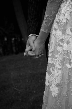 Gelin ve damat parkta el ele tutuşuyorlar.