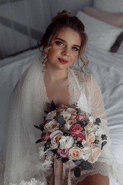 Çekici genç gelin elinde güzel bir düğün buketi tutuyor              