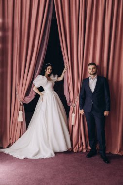 Güzel gelin ve damat stüdyoda birlikte poz veriyorlar.