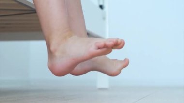 Ayak ve ayak egzersizi yapan bir çocuk. Düz taban önleme kavramı. Düz taban fizik tedavi. Düşük açı, yakın çekim. Yüksek kaliteli FullHD görüntüler