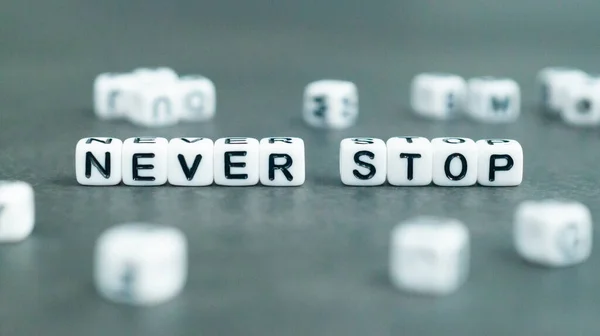 Nikdy Nepřestávej Slogan Bílých Kuličkách Koncept Úspěchu Sebedůvěry Kvalitní Fotografie — Stock fotografie