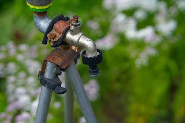 Su hortumunu bağlamak için musluğu olan eski el yapımı bahçe sulama tezgahı.              