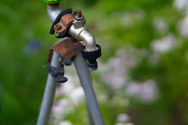 Su hortumunu bağlamak için musluğu olan eski el yapımı bahçe sulama tezgahı.              