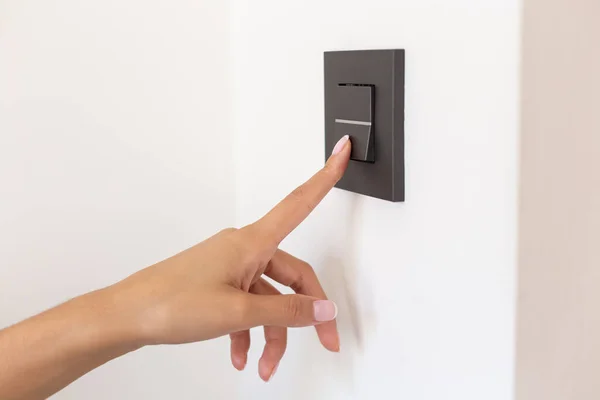 stock image Close up of young woman's hand pressing the light switch button 