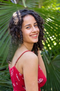 Kıvırcık saçlı genç bir kadın cennette eğleniyor. 