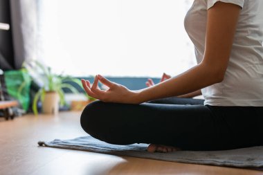 Evde yoga yapan tanınmayan genç bir kadın.