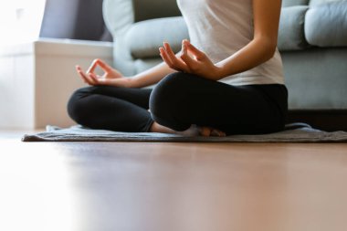 Evde yoga yapan tanınmayan genç bir kadın.