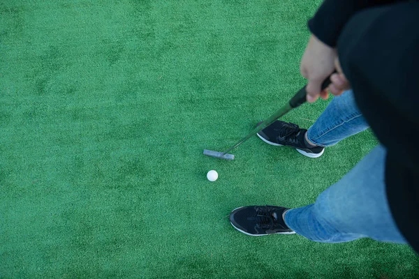 Top view of a unrecognizable golfer playing miniature golf 