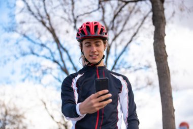 Parkta selfie çeken mutlu bisikletçi.