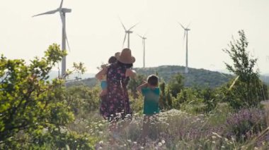 Anne çocuklara rüzgar çiftliğini gösterir. Yel değirmenleri tarafından ekolojik enerji üretimi. Yüksek kalite 4k görüntü