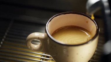 Kahve makinesinden fincana dökülen yavaş çekim espresso videosu. Bir kafede bir baristanın profesyonel kahve hazırlığı. Yüksek kalite 4k görüntü