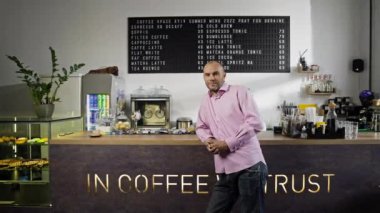 Küçük bir kahve dükkanının sahibi olan işadamı tebrik ediyor. Kahve dükkanında üniformalı bir barista gülümsüyor. Yüksek kalite 4k görüntü