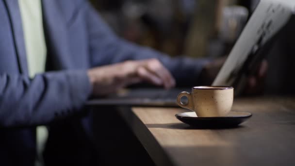 Egy Férfi Egy Kávézóban Dolgozik Egy Számítógépnél Közelkép Egy Csésze — Stock videók