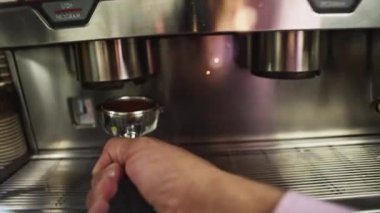 Bir baristanın kahve makinesine kurcalayıcı yerleştirdiği yakın plan. Bir kafede kokulu kapuçino ve espresso yapma süreci. Yüksek kalite 4k görüntü
