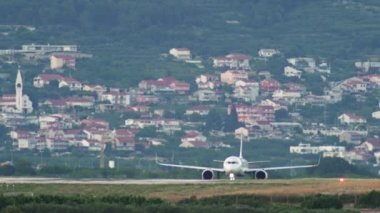 Uçak şehrin arka planına karşı pist üzerinde ilerliyor. Şehir manzarası ve havaalanı hayatı. Yüksek kalite 4k görüntü
