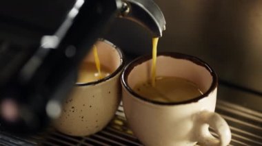 Kahve makinesinden kahve fincanına yavaş çekimde espresso dökülüyor. Kafede çalışan profesyonel bir baristanın kapuçino hazırlığı. Yüksek kalite 4k görüntü