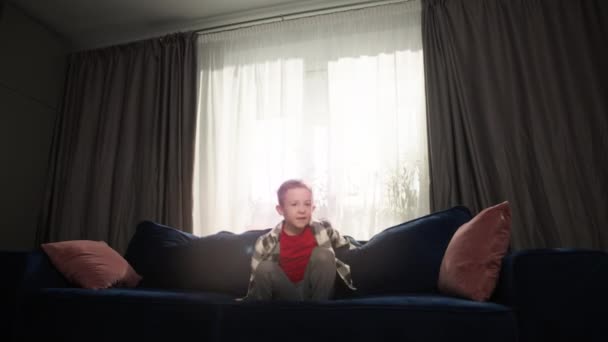 Boldog Jókedvű Fiú Bolondozik Otthon Kanapén Egy Kaukázusi Gyerek Boldog — Stock videók