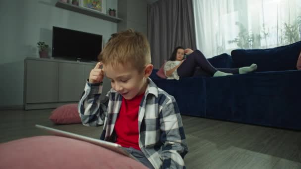 Chłopiec Bawi Się Tablecie Matka Leży Kanapie Korzysta Telefonu Rodzina — Wideo stockowe