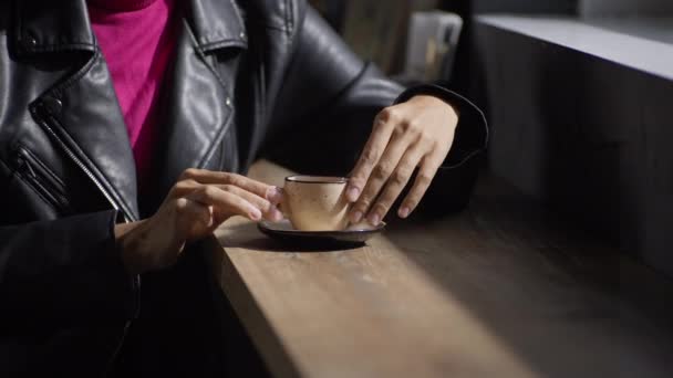 女の子のクローズアップは コーヒーを飲んで味を楽しんでいます アフリカ系アメリカ人の美しい女性がカフェでカプチーノを飲みます 高品質4K映像 — ストック動画