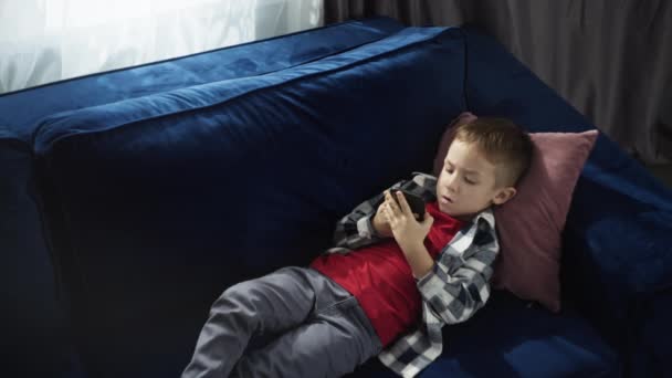 Lifestyle Barn Pojke Ligger Soffan Och Spelar Spel Telefonen Barnet — Stockvideo