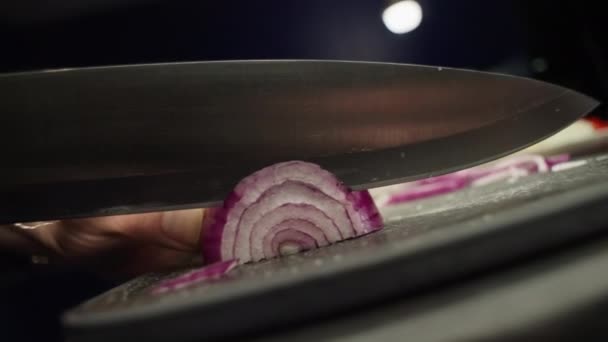 切り取り板にナイフで玉ねぎをスライスするスローモーションビデオのクローズアップ 台所で家庭で調理 食材をスライス 高品質4K映像 — ストック動画
