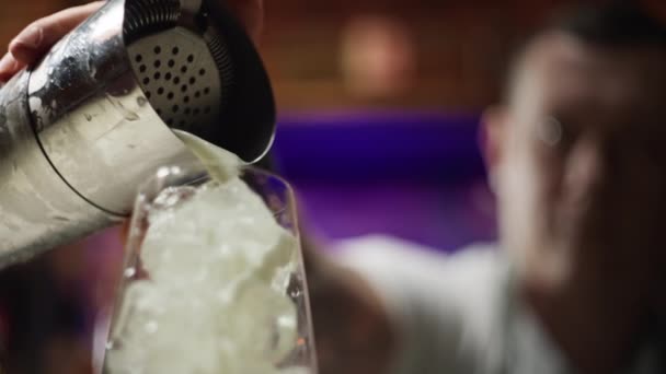 将鸡尾酒从摇瓶倒入加冰的杯子中的特写 鸡尾酒会上由一位专业的酒保在酒吧里为一个派对做鸡尾酒的过程 高质量的4K镜头 — 图库视频影像