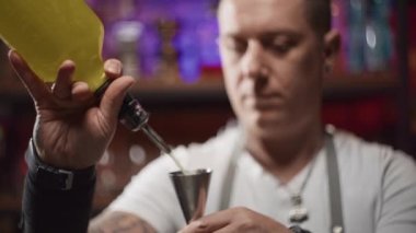 Profesyonel bir barmen ölçü kabına alkol döker. Bardaki bir kulüpte kokteyl yapma süreci. Yaşam tarzı video partisi. Yüksek kalite 4k görüntü