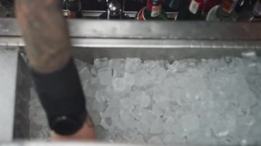 Profesyonel bir barmen buzu karıştırıcıya atar. Barda soğuk kokteyl hazırlığı. Kulüpteki bir partide alkollü içkilerin yaşam tarzı. Yüksek kalite 4k görüntü