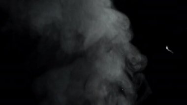 Siyah arkaplandaki dumanın soyut arkaplanı tepeye yükseliyor. Güzel bir video kaynar suyun dumanını yavaşlatacak. Yüksek kalite 4k görüntü