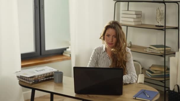 ある女性は自宅のコンピュータで働いている 女性が自宅のリビングルームのノートパソコンのキーボードを入力しています ビジネスマンはオンラインで働き 仕事を完了する 高品質4K映像 — ストック動画