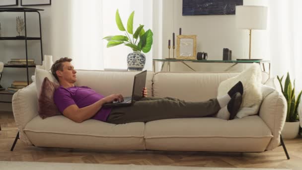 Muž Pracuje Počítačem Doma Zatímco Leží Gauči Pohodlná Vzdálená Práce — Stock video