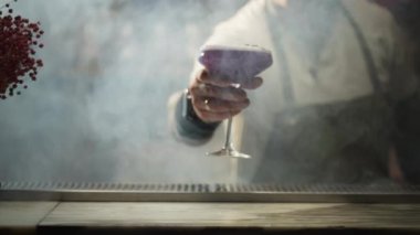 The bartender puts the finished decorated cocktail on the bar counter. Party at the bar in the club. Having fun. alcohol. High quality 4k footage