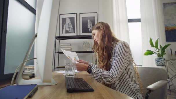 白人女性はコンピュータにコップ一杯の水を注ぐ ビジネスウーマンはガラスを職場に投げつけます その少女は自宅のオフィスで気まずい働きをする 高品質4K映像 — ストック動画