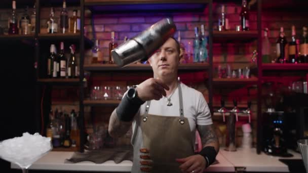 Attractive Bartender Mixes Ingredients Cocktail Shaker Piercing Gaze Man Work — Stockvideo