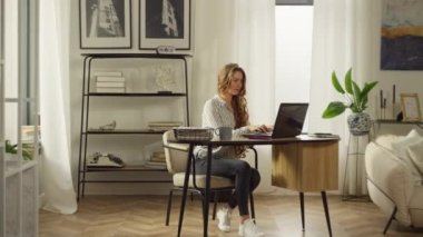 Caucasian woman working at computer in home office. Businesswoman finishes work, finishes business and smiles contentedly. High quality 4k footage