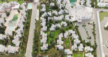 Aerial view of a luxury area with villas in the suburbs. Beautiful houses on streets with greenery and trees. A heavenly place to live. High quality 4k footage