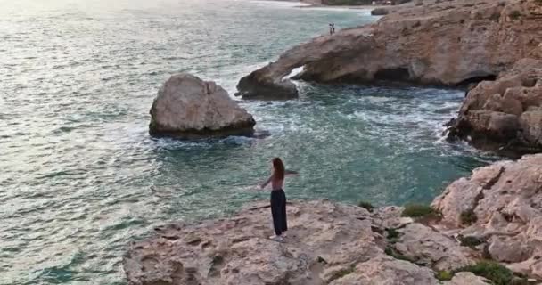 Aerial View Happy Woman Edge Rocks Seashore Her Arms Crossed — Vídeo de Stock