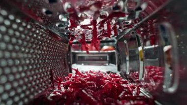 Slow motion video of a chef grating a beetroot in a restaurant kitchen. Cutting vegetables for dishes by a professional. High quality 4k footage