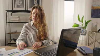 Businesswoman at an online business meeting from home with a laptop and talking in pajamas. Funny video work from home online. High quality 4k footage