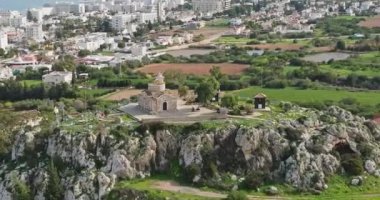Aerial view of the church on the mountain in Cyprus. A beautiful landscape with a religious building. Cityscape of buildings and villages on the seashore. High quality 4k footage