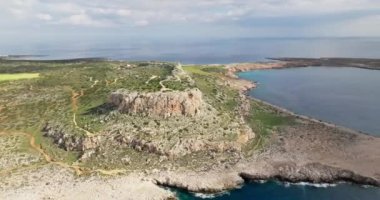 Deniz kıyısındaki bir dağ kanyonunun havadan görünüşü. Suyun ve karanın dokunuşunun doğasının güzel bir manzarası. Okyanus kıyısındaki yamaçlar ve kayalıklar. Yüksek kalite 4k görüntü