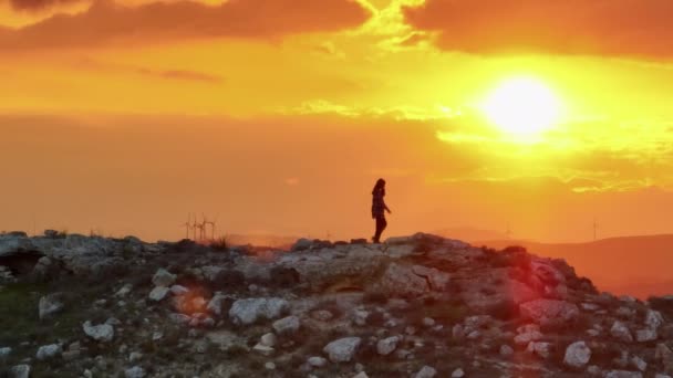 日没時に山の上に女の子 美しい風景の中に太陽を見て女性の空中ビュー 自然だけで自由を感じます 高品質4K映像 — ストック動画