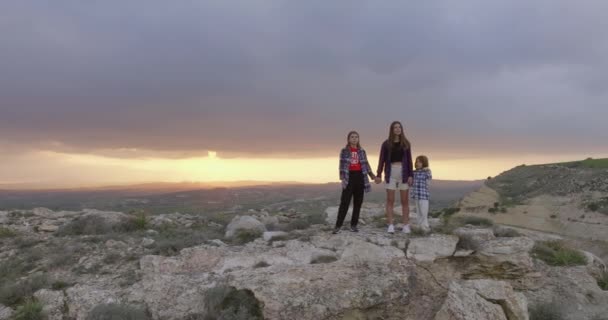 日没時には山の上の空中ビューライフスタイルファミリー 母親と2人の娘が一緒に山の範囲の性質を賞賛する ハイキングで旅行するのは嬉しい 高品質4K映像 — ストック動画