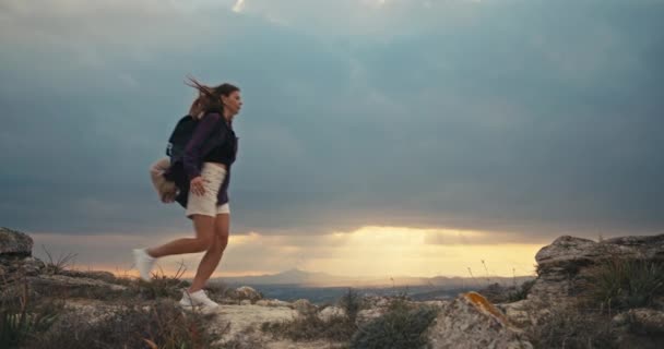 子供を持つ女性は日没時に山の中をハイキングしています 家族は山の頂上に一緒に旅行します — ストック動画