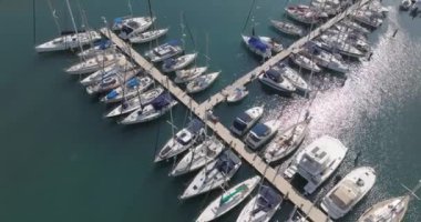 Aerial view of the marina with moored yachts and boats. Close-up of a pier in the sea near which boats stand. High quality 4k footage