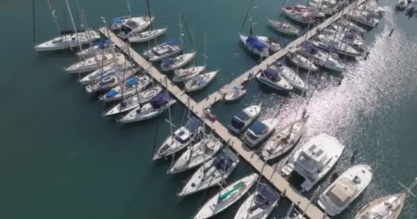 係留ヨットやボートとマリーナの空中ビュー 近くの船が立つ海の中の桟橋のクローズアップ 高品質4K映像 — ストック動画