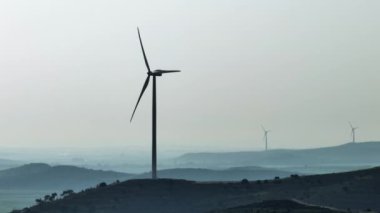 Dağlarda dönen yel değirmeni ve türbinlerin destansı videosu. Yeşil enerji, ekoloji ve alternatif rüzgar enerjisi. Yüksek kalite 4k görüntü