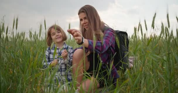 Мать Ребенок Трогают Зеленую Траву Руками Поле Женщина Рассказывает Ребенку — стоковое видео